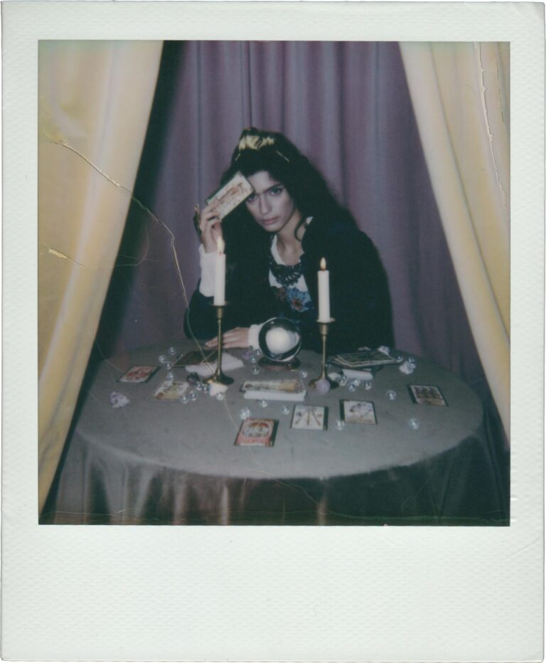 A captivating scene of a fortune teller with tarot cards and candles on a round table.